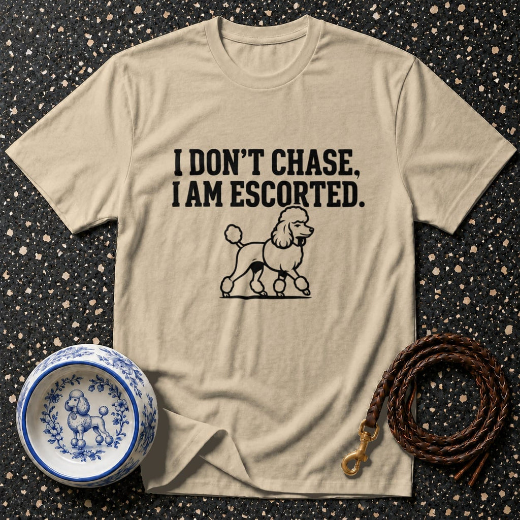 Beige t-shirt with "I DON'T CHASE, I AM ESCORTED" and poodle graphic.