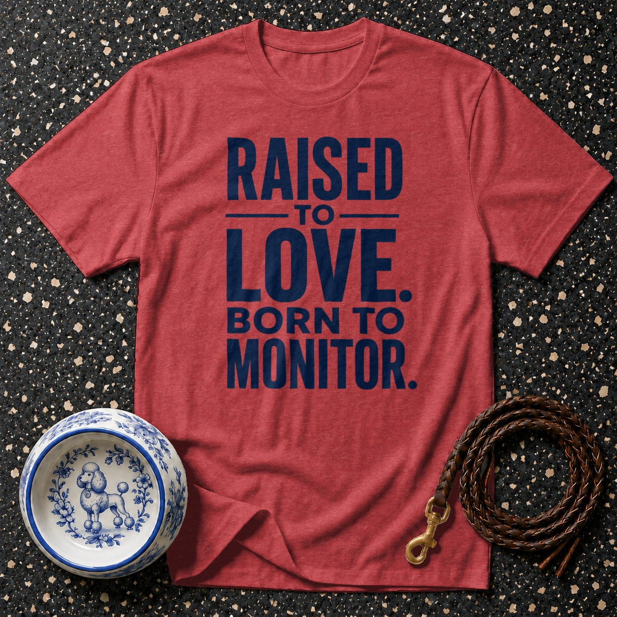Red t-shirt with navy text "RAISED TO LOVE. BORN TO MONITOR."