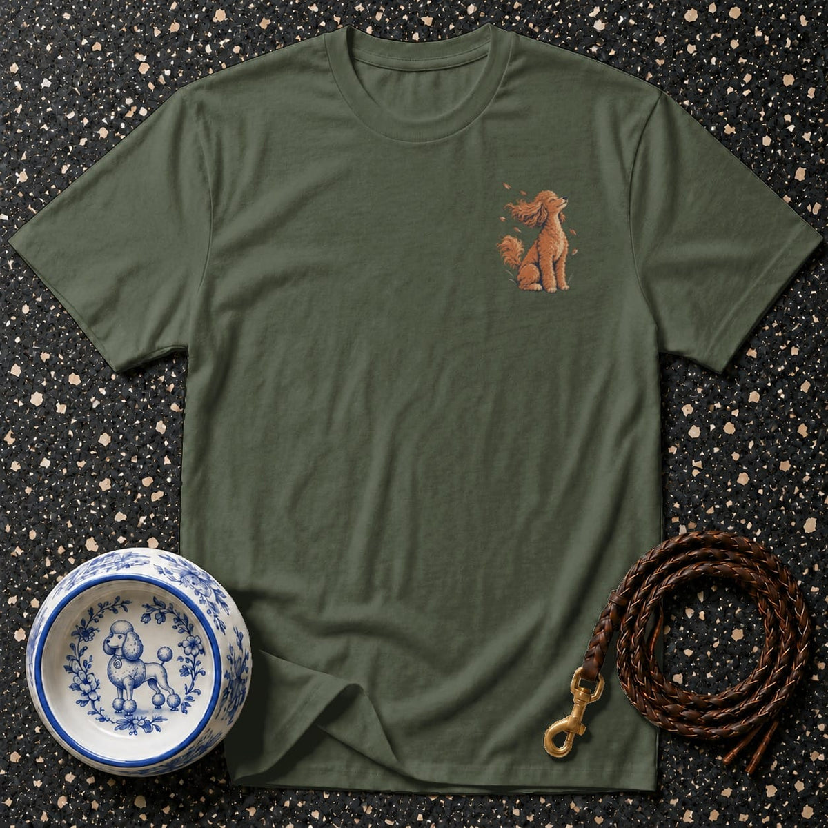 Olive green t-shirt with a small, detailed illustration of a seated poodle and a coiled leather leash.