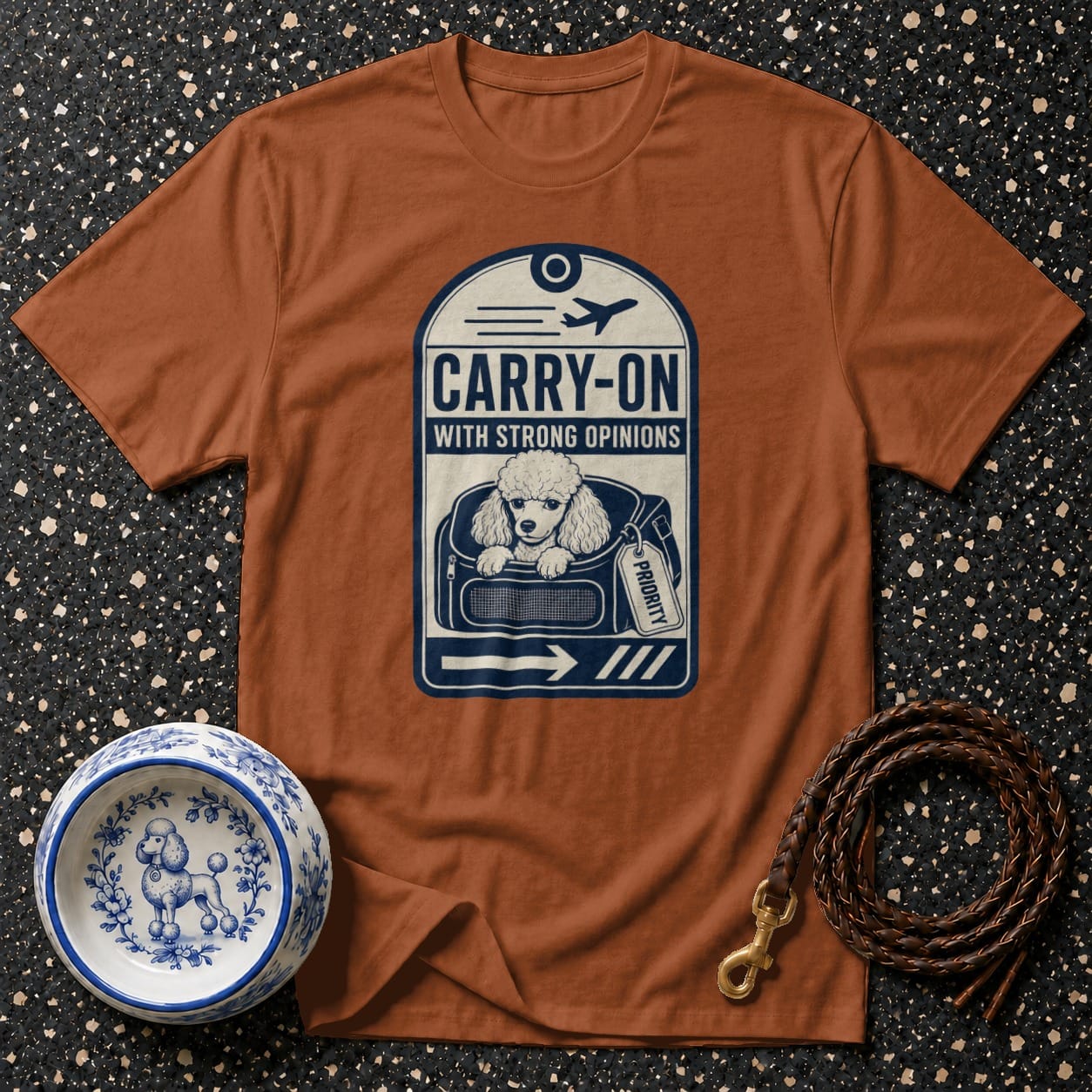Brown t-shirt with "Carry-On With Strong Opinions" and a poodle in a bag.