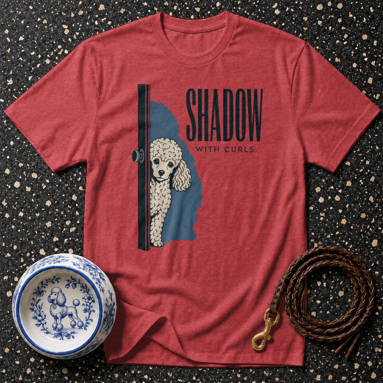 Red t-shirt with poodle peeking from behind a door and text "SHADOW WITH CURLS."