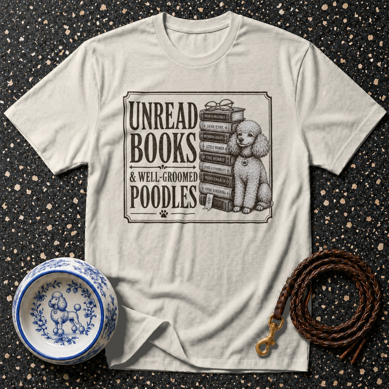 T-shirt with "Unread Books & Well-Groomed Poodles" text and poodle sitting on books.