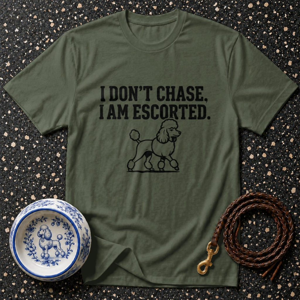 Olive t-shirt with black text "I DON'T CHASE, I AM ESCORTED" and poodle illustration.