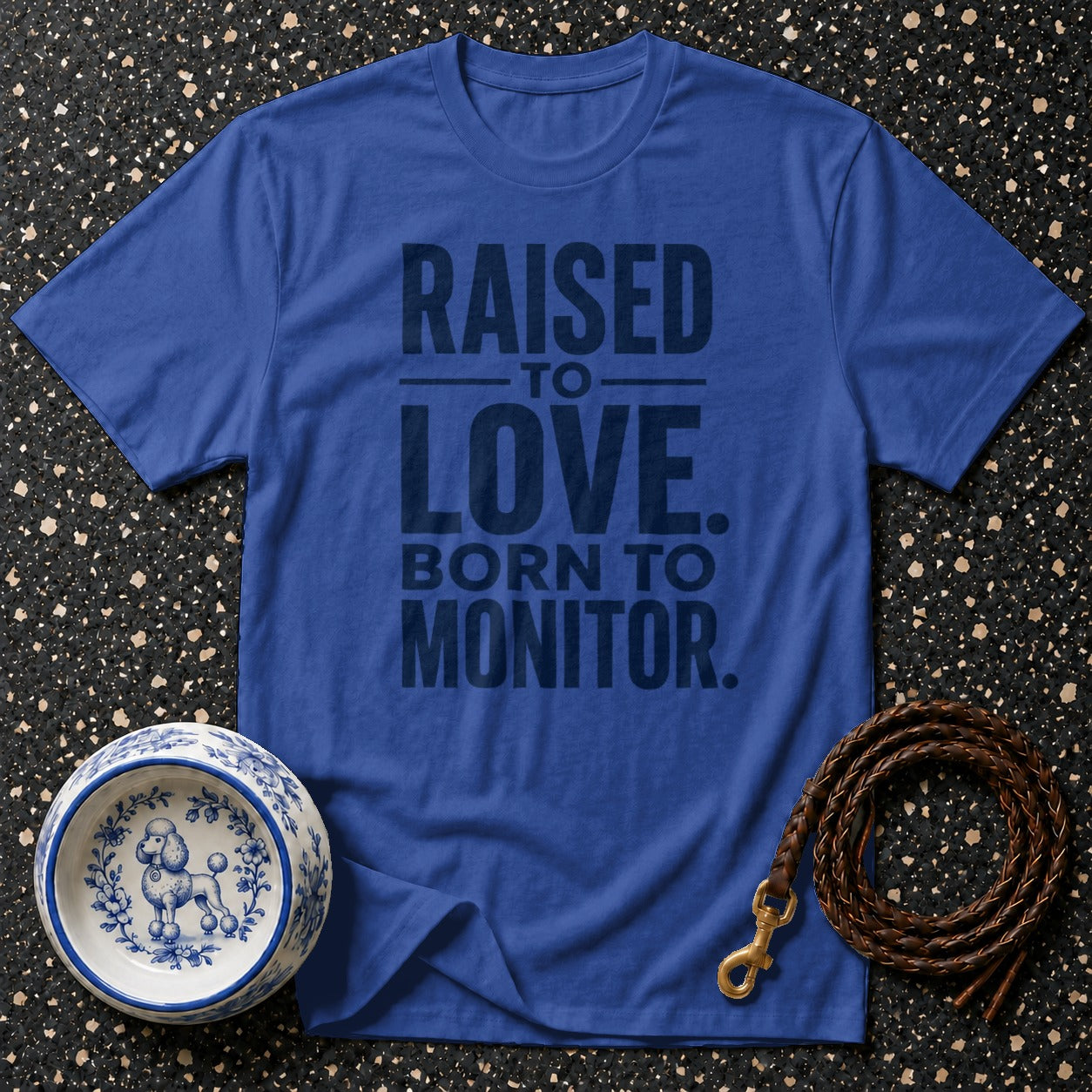 Blue t-shirt with "Raised to Love, Born to Monitor" text, dog bowl, and leash.