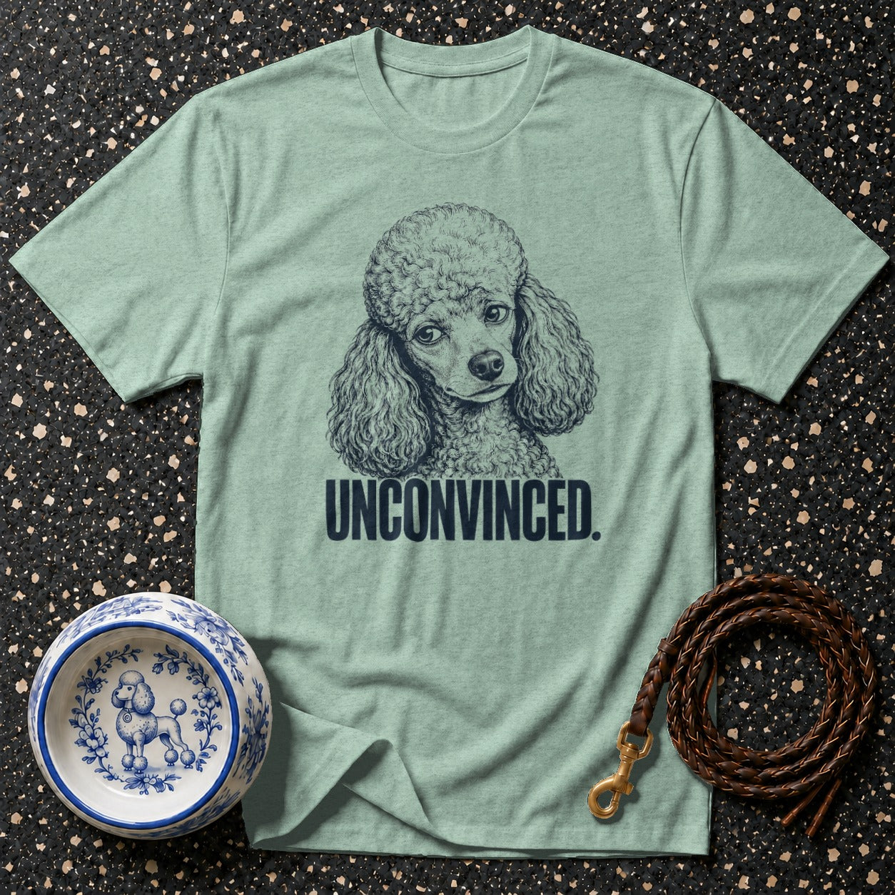 Light green t-shirt with poodle graphic and text "UNCONVINCED."