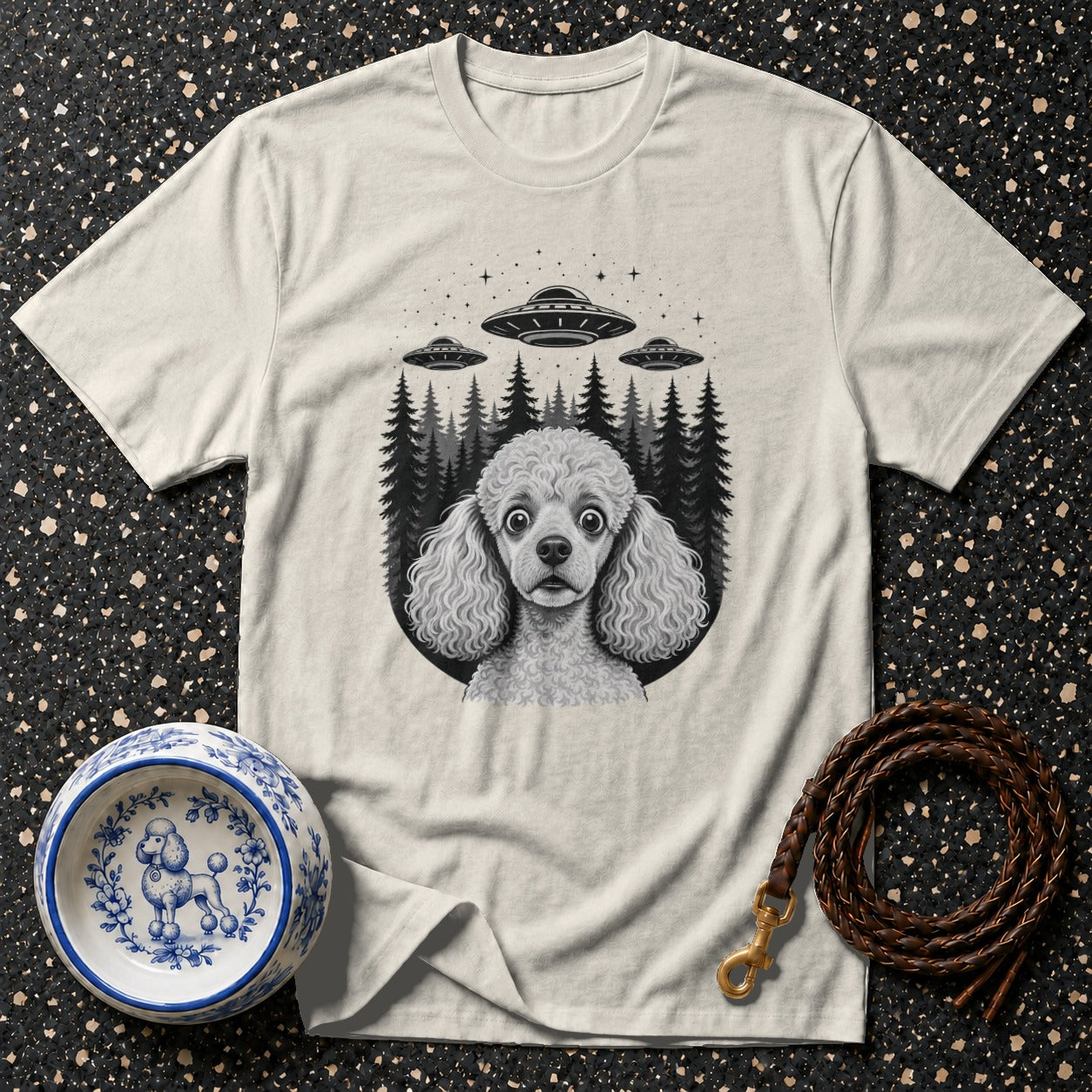 Cream t-shirt with illustrated poodle and three UFOs over a forest.