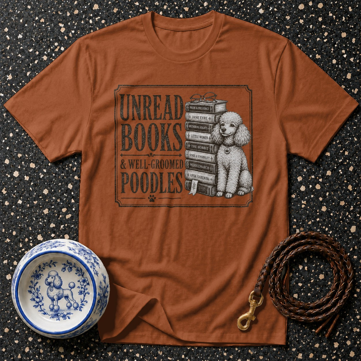 T-shirt graphic with text "Unread Books & Well-Groomed Poodles", books, and poodle.