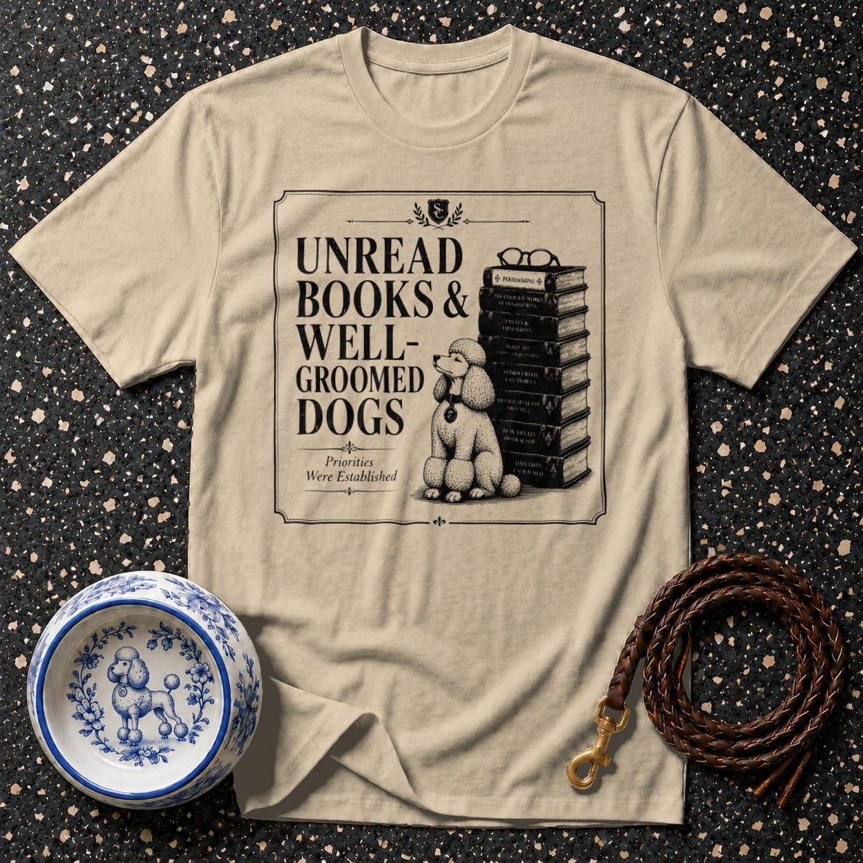 T-shirt graphic reads "Unread Books & Well-Groomed Dogs" with a poodle beside books.