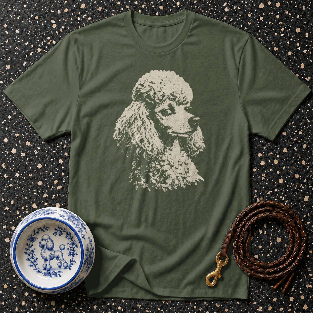Olive green t-shirt with white poodle graphic, blue and white dog bowl, and leather leash.