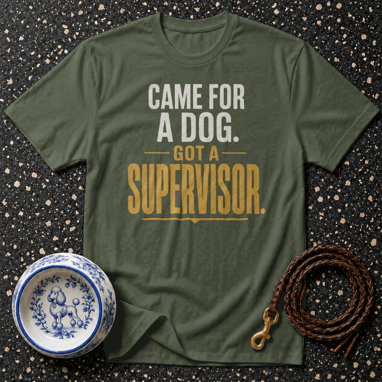 Green t-shirt with white and gold text "CAME FOR A DOG. GOT A SUPERVISOR."