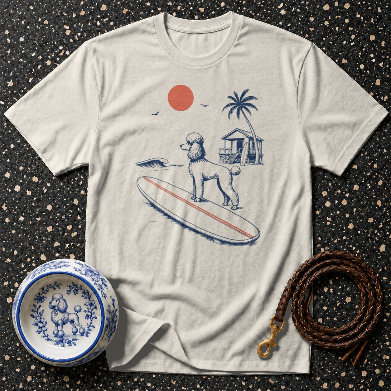 T-shirt with a doodle surfing on a surfboard at a beach with a cabin.