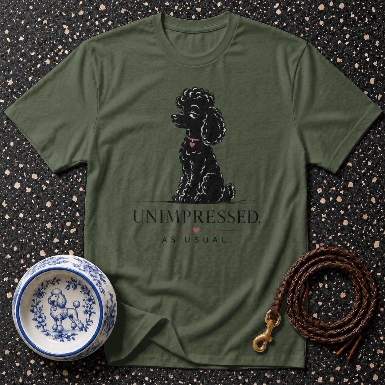 Olive t-shirt with a black poodle illustration and text "UNIMPRESSED, AS USUAL."