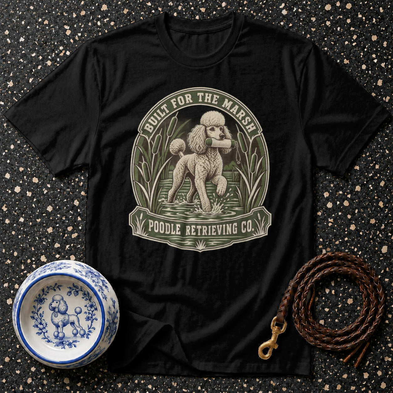 Black t-shirt with a poodle retrieving a stick in a marsh, text "BUILT FOR THE MARSH POODLE RETRIEVING CO."