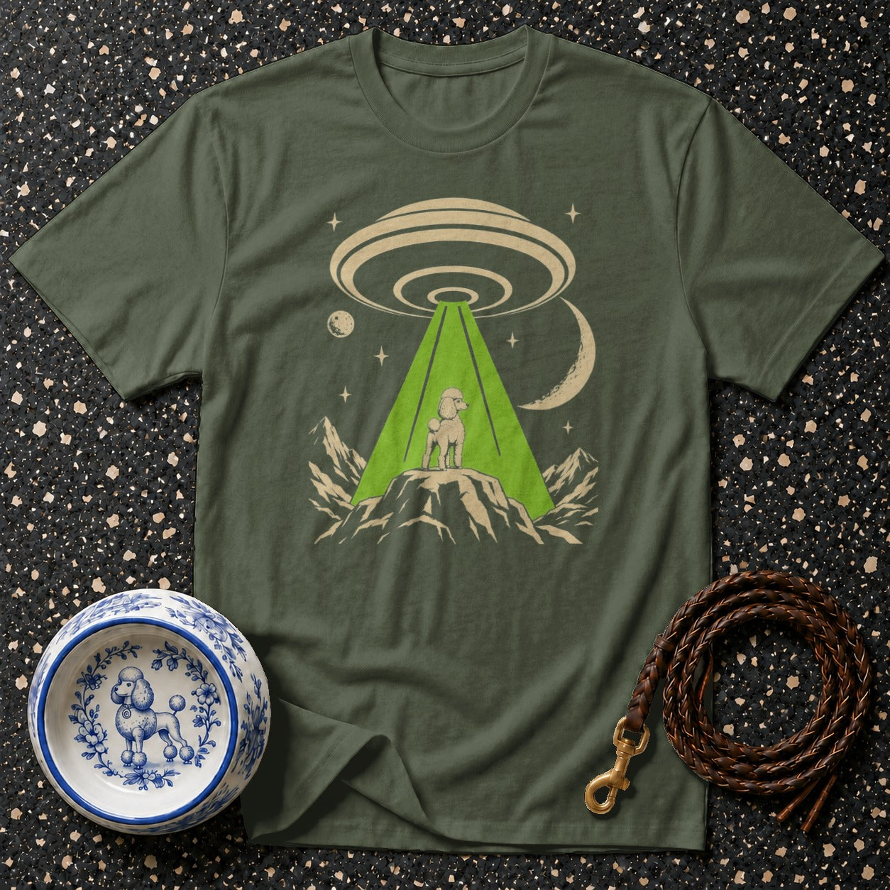 Olive green t-shirt with a poodle on a mountain under a UFO beam.