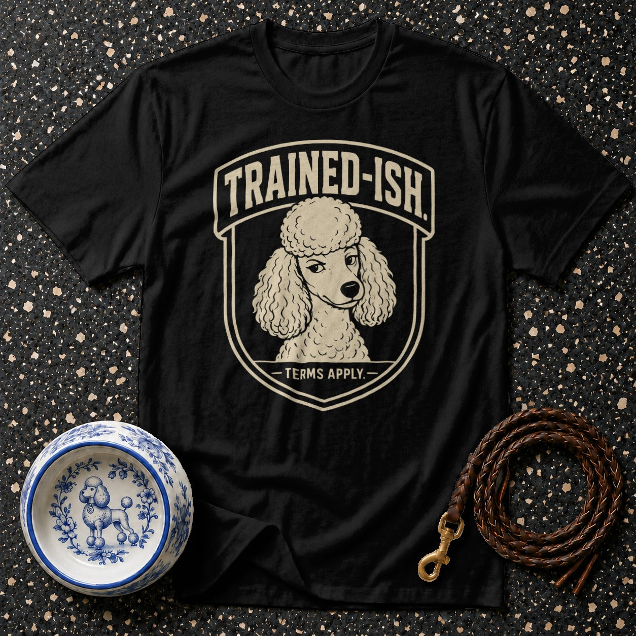 Black t-shirt with poodle graphic and "TRAINED-ISH - TERMS APPLY." text.