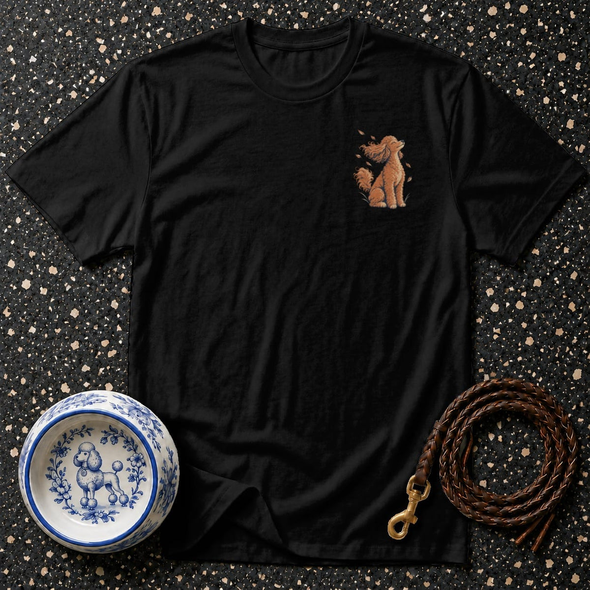 Black t-shirt with a small embroidered poodle graphic and surrounding fall leaves.