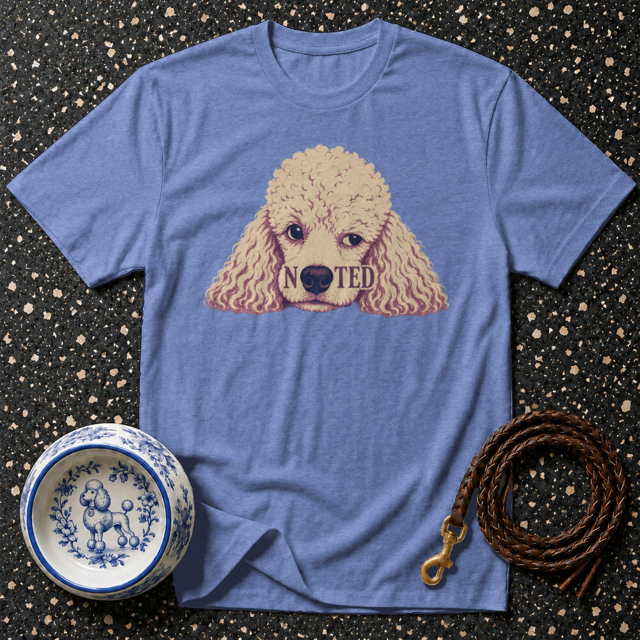 Blue t-shirt with a poodle graphic reading "NOTED".