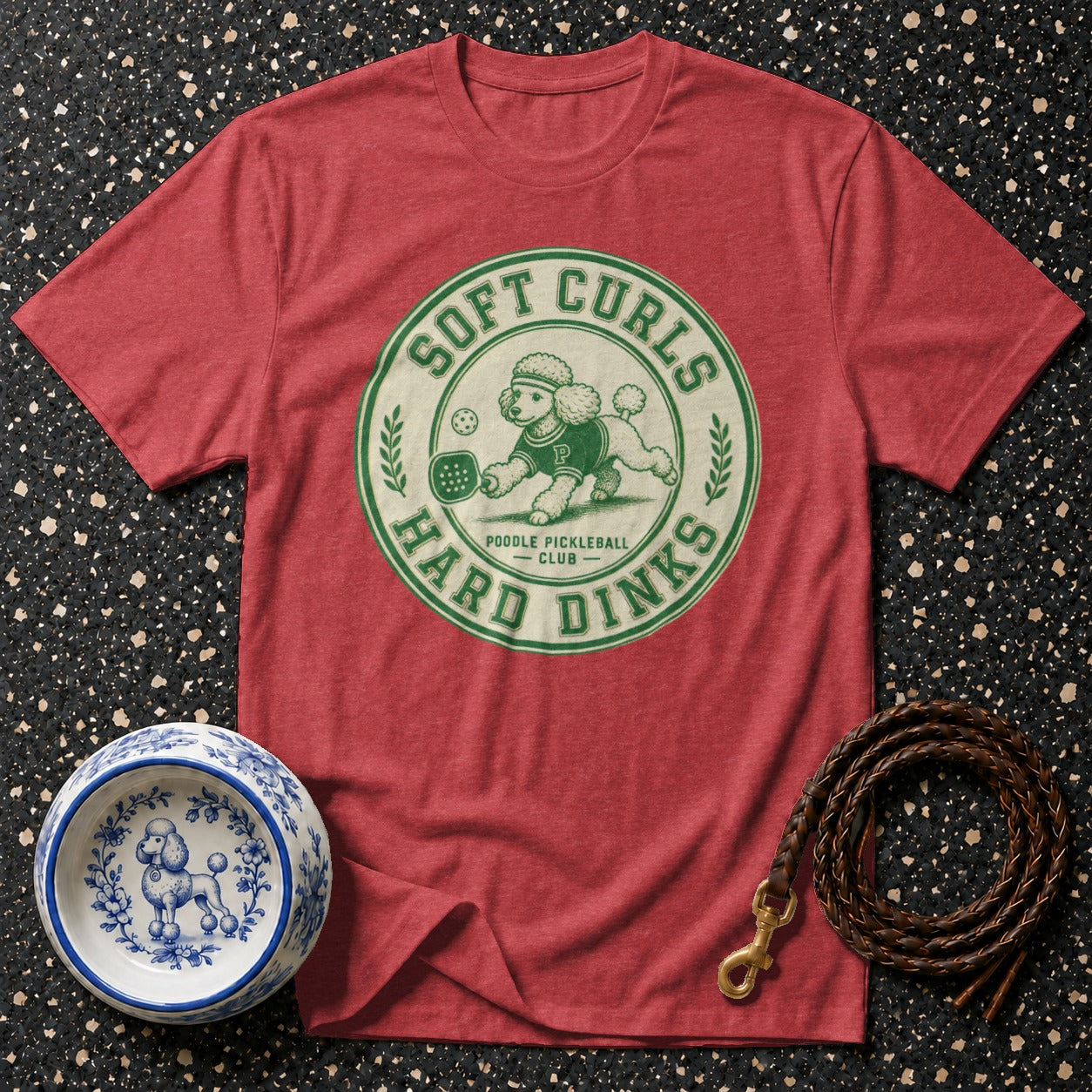 Red t-shirt with graphic of poodle playing pickleball, "Soft Curls Hard Dinks"
