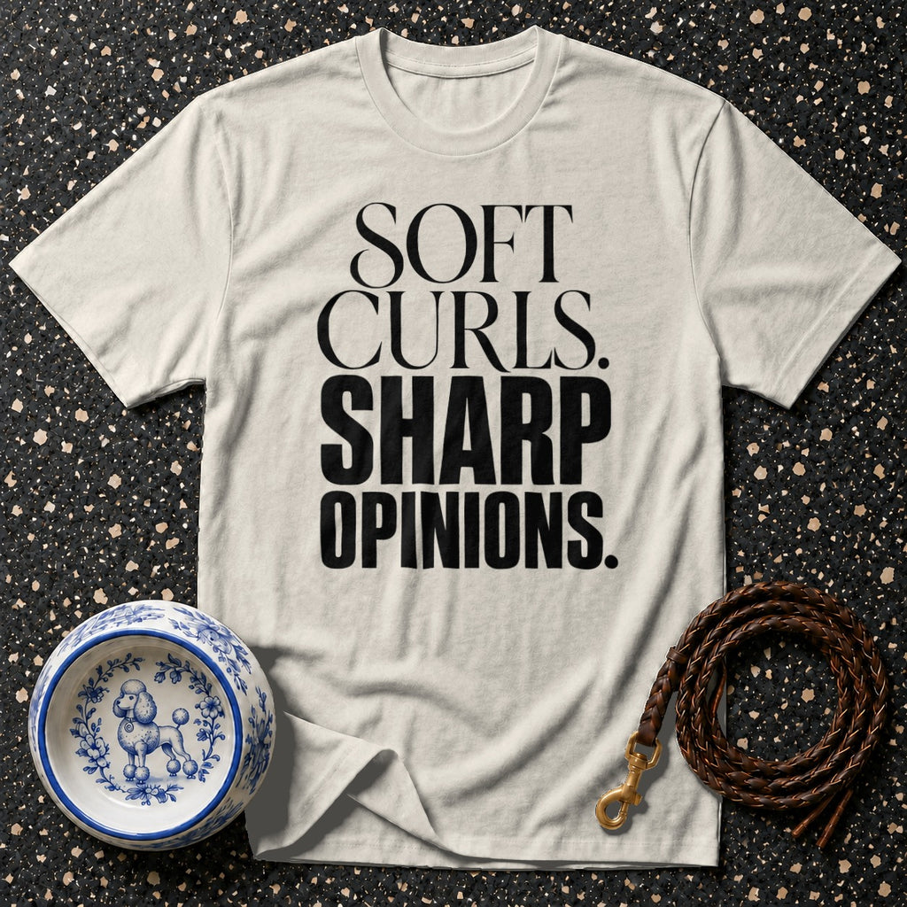 Cream t-shirt with black text "SOFT CURLS. SHARP OPINIONS." next to dog bowl and leash.