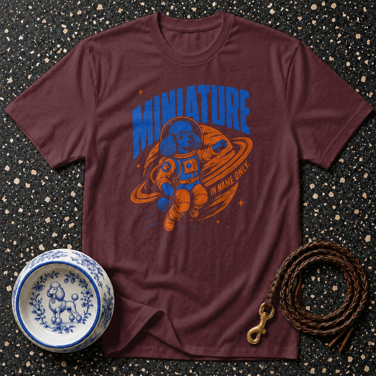 T-shirt with a blue poodle in an orange astronaut suit floating in space.