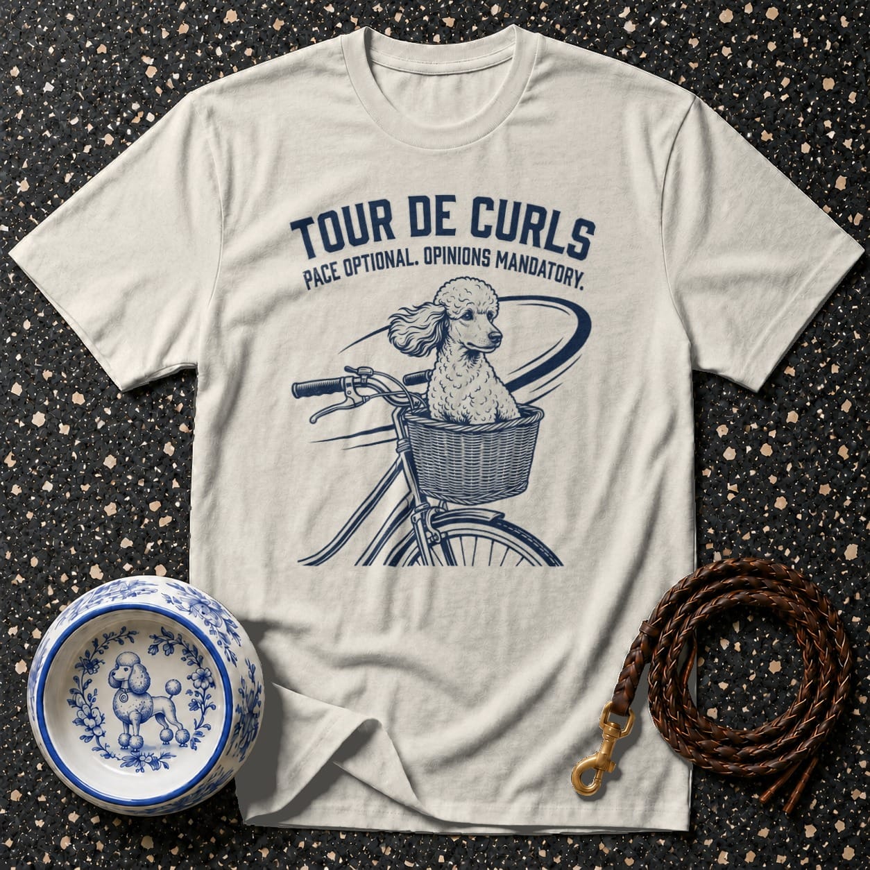 Cream t-shirt with graphic of poodle in bicycle basket and text "Tour De Curls".