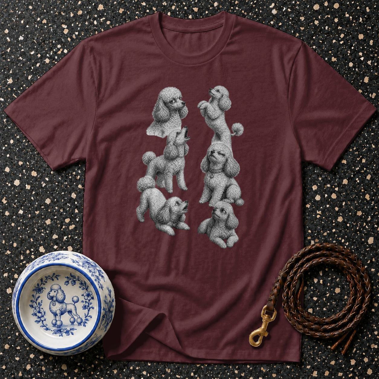 Maroon t-shirt with multiple grey poodle illustrations and a decorative dog bowl.