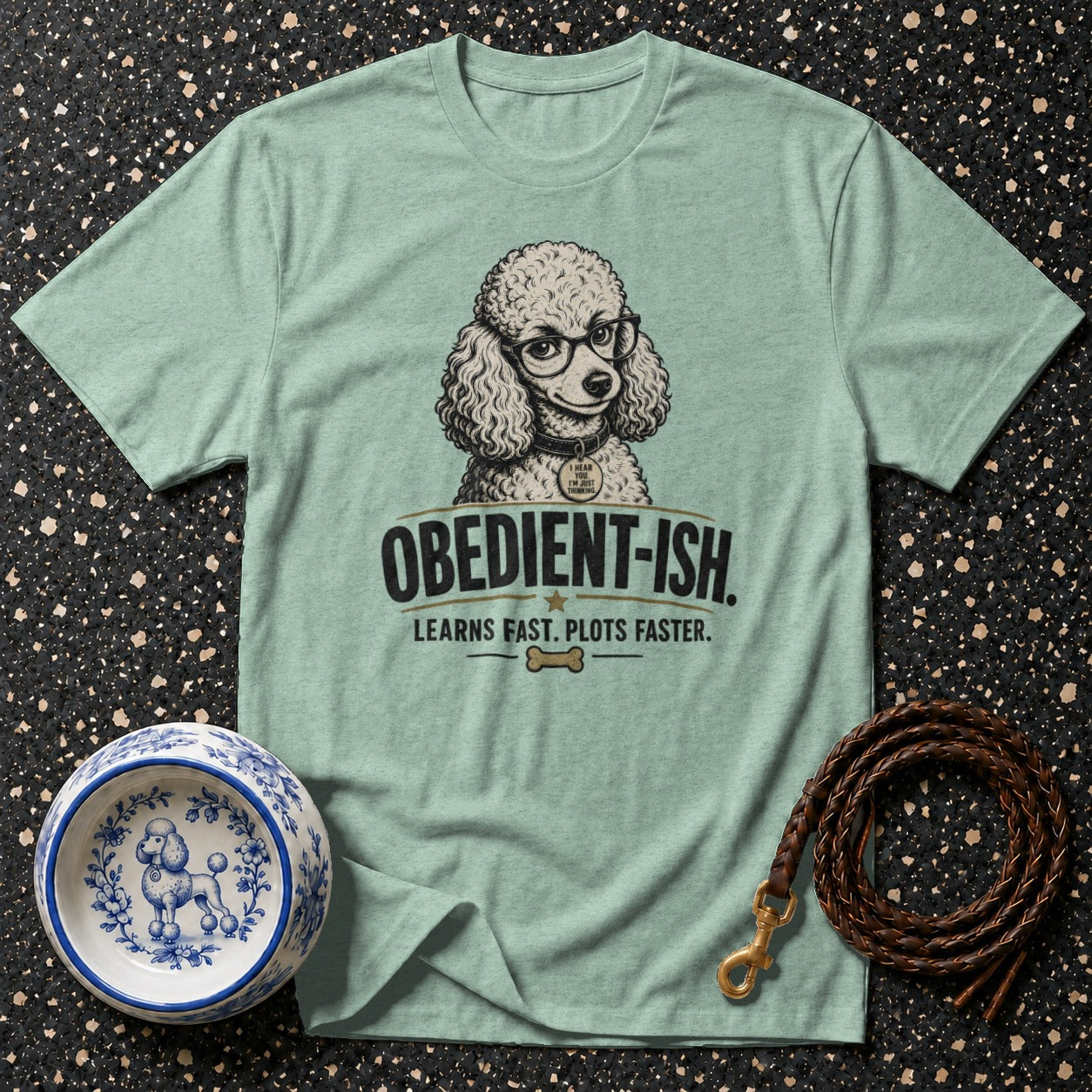 Light green t-shirt with illustration of a poodle wearing glasses and text "OBEDIENT-ISH."