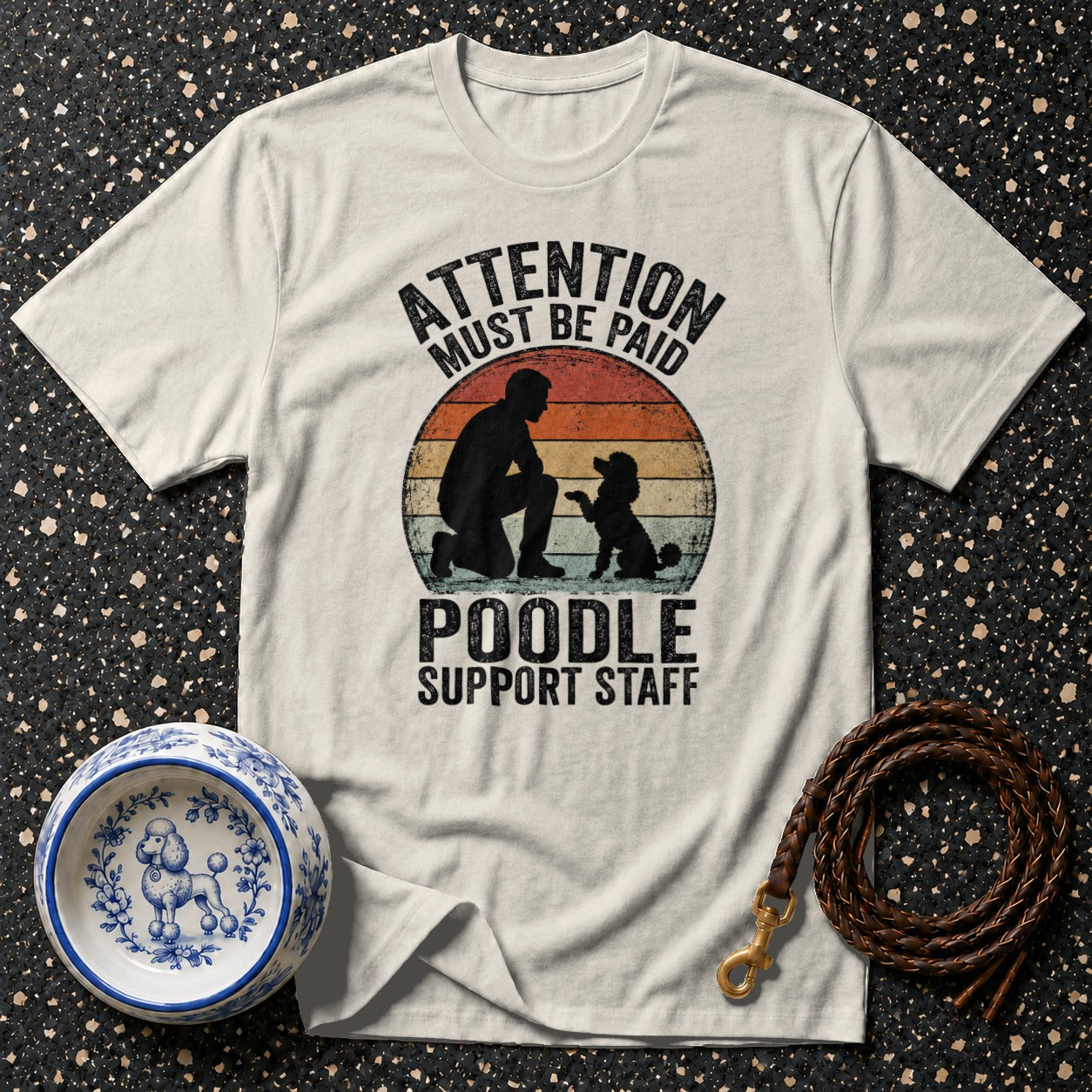 White t-shirt with "ATTENTION MUST BE PAID POODLE SUPPORT STAFF" graphic.
