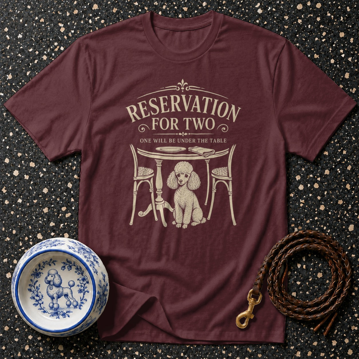 Maroon t-shirt with "Reservation for Two" and poodle under a table graphic.