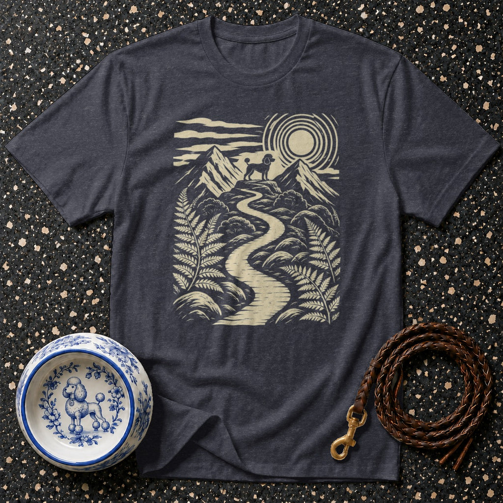 Dark t-shirt with a poodle on a mountain path design, next to a decorative dog bowl and leash.