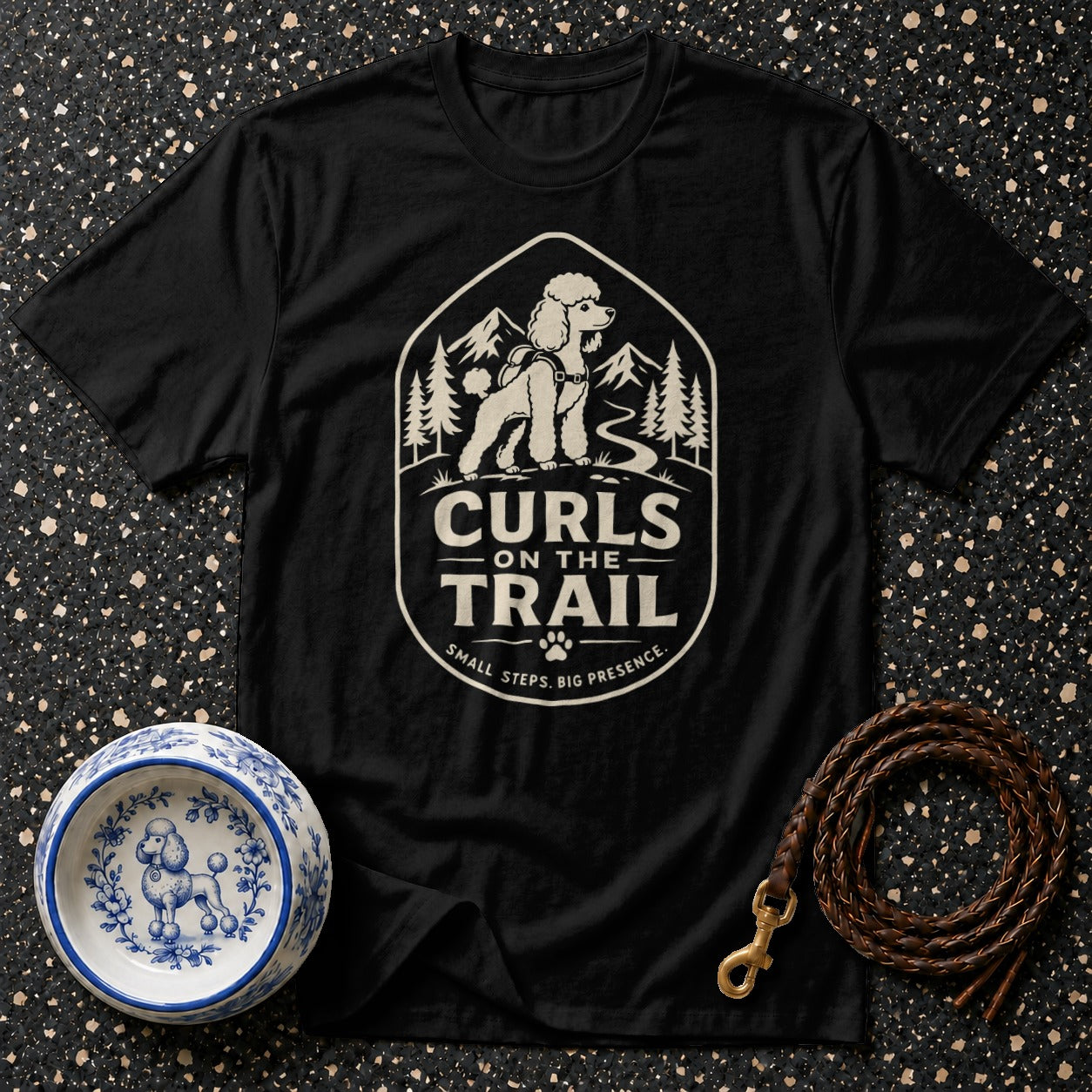 Black t-shirt with "Curls on the Trail" graphic of a poodle on a mountain background.