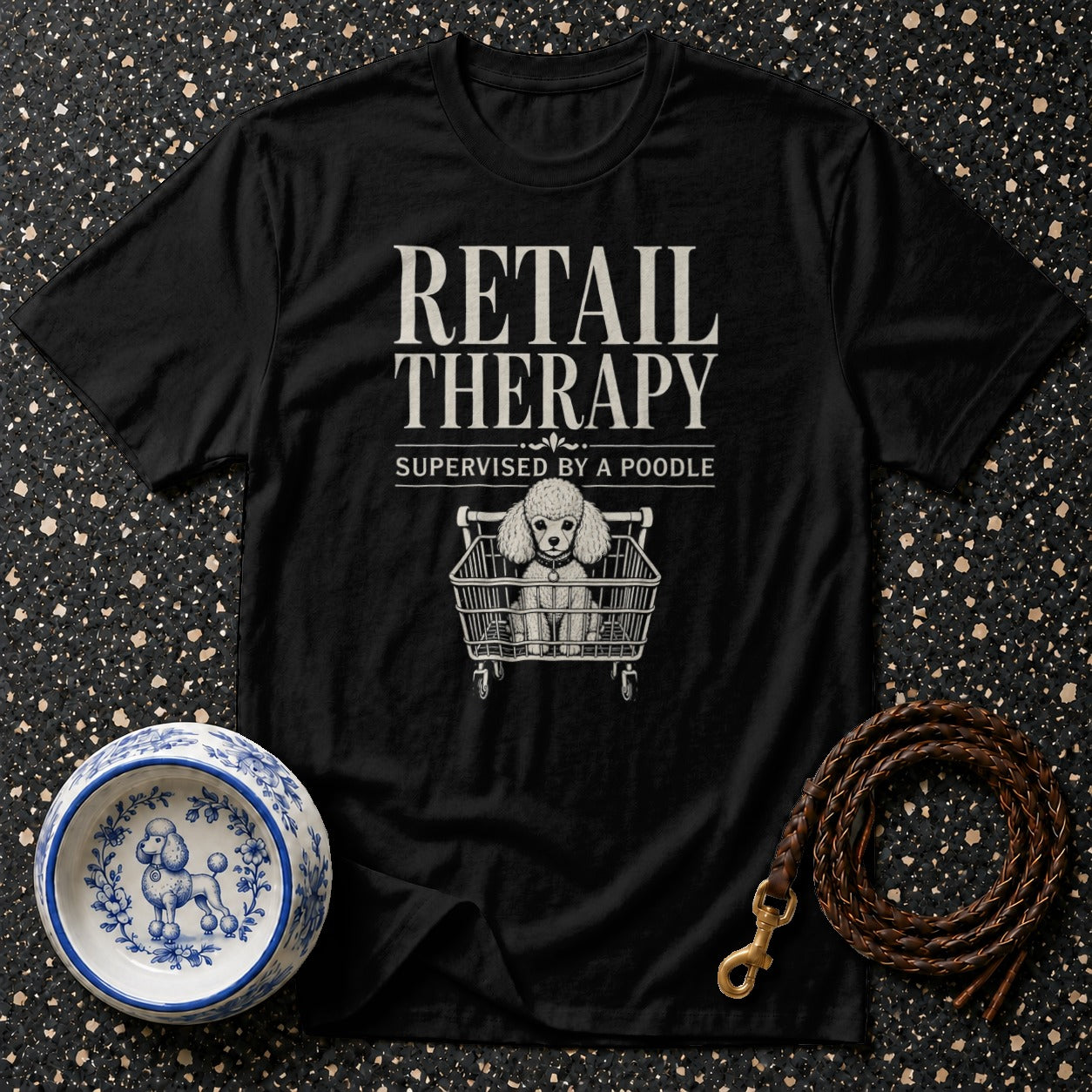 Black t-shirt with "Retail Therapy Supervised by a Poodle" text and poodle in shopping cart graphic.