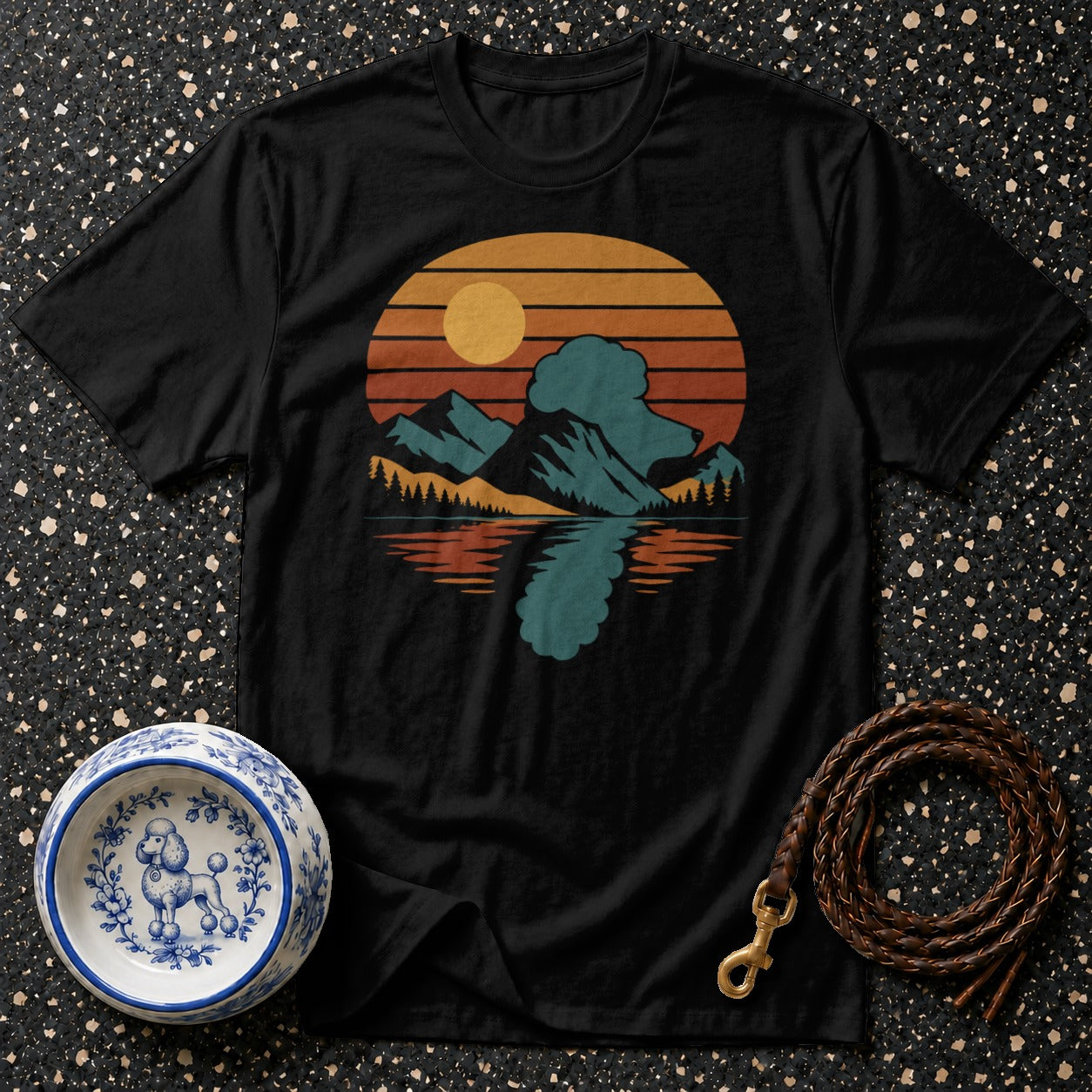 Black t-shirt with a retro mountain sunset graphic and a poodle design on a bowl.