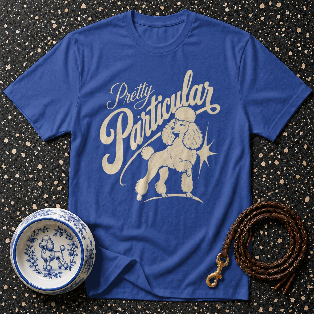 Blue t-shirt with "Pretty Particular" text and a poodle graphic.