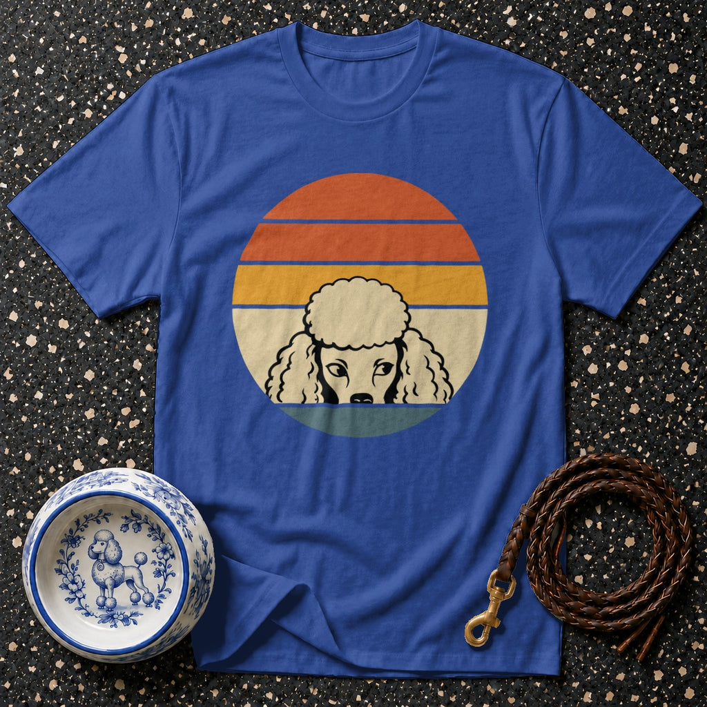 Blue t-shirt with vintage poodle graphic on sunset background, pet bowl, and leash.