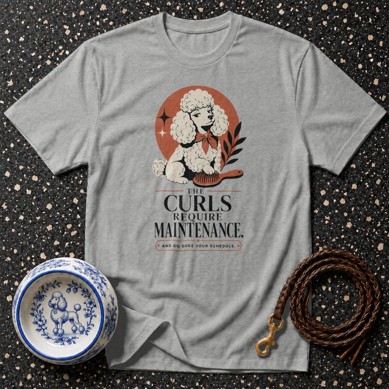 Grey t-shirt with a graphic of a poodle and the text "The Curls Require Maintenance."