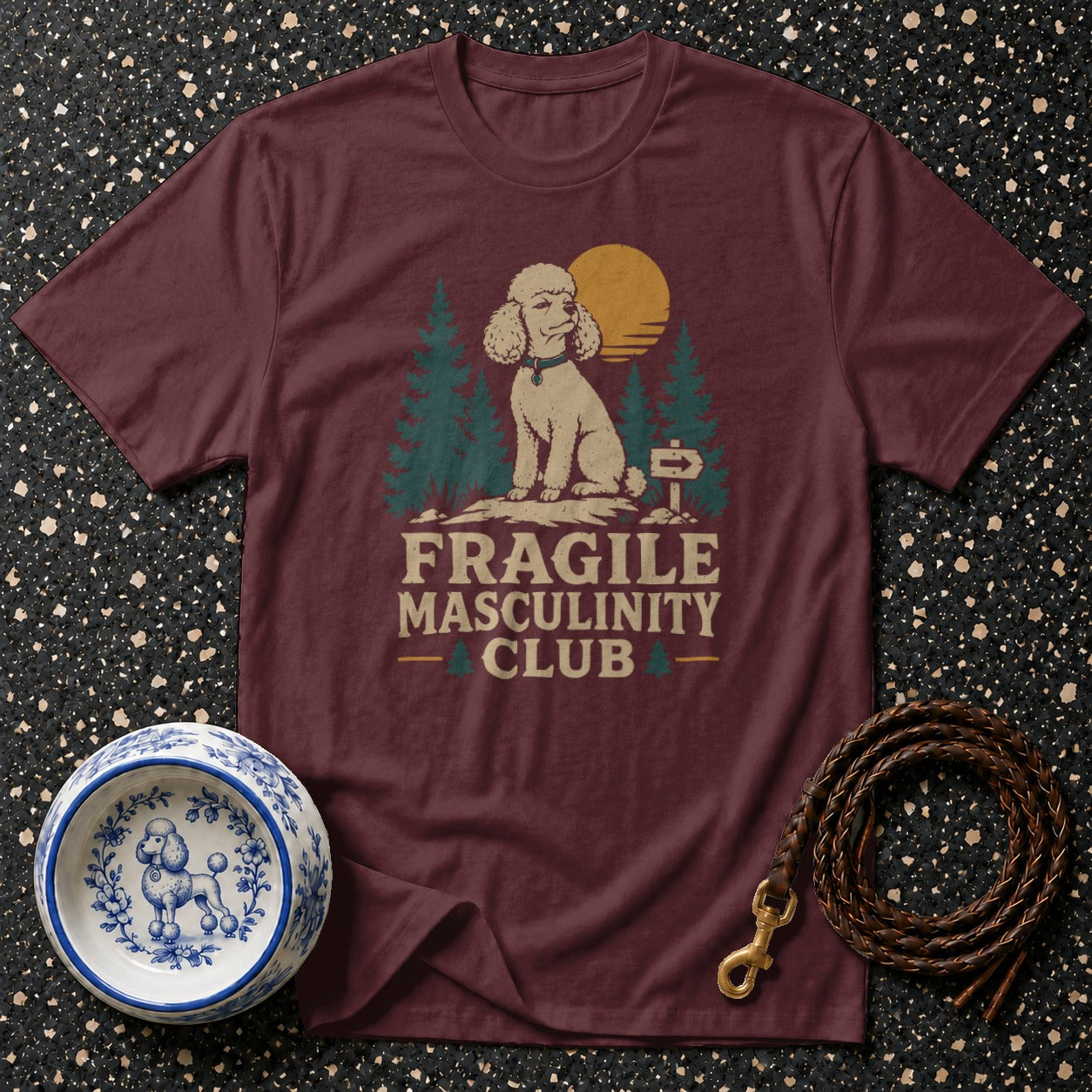 Maroon t-shirt with vintage illustration of a poodle and text "FRAGILE MASCULINITY CLUB".