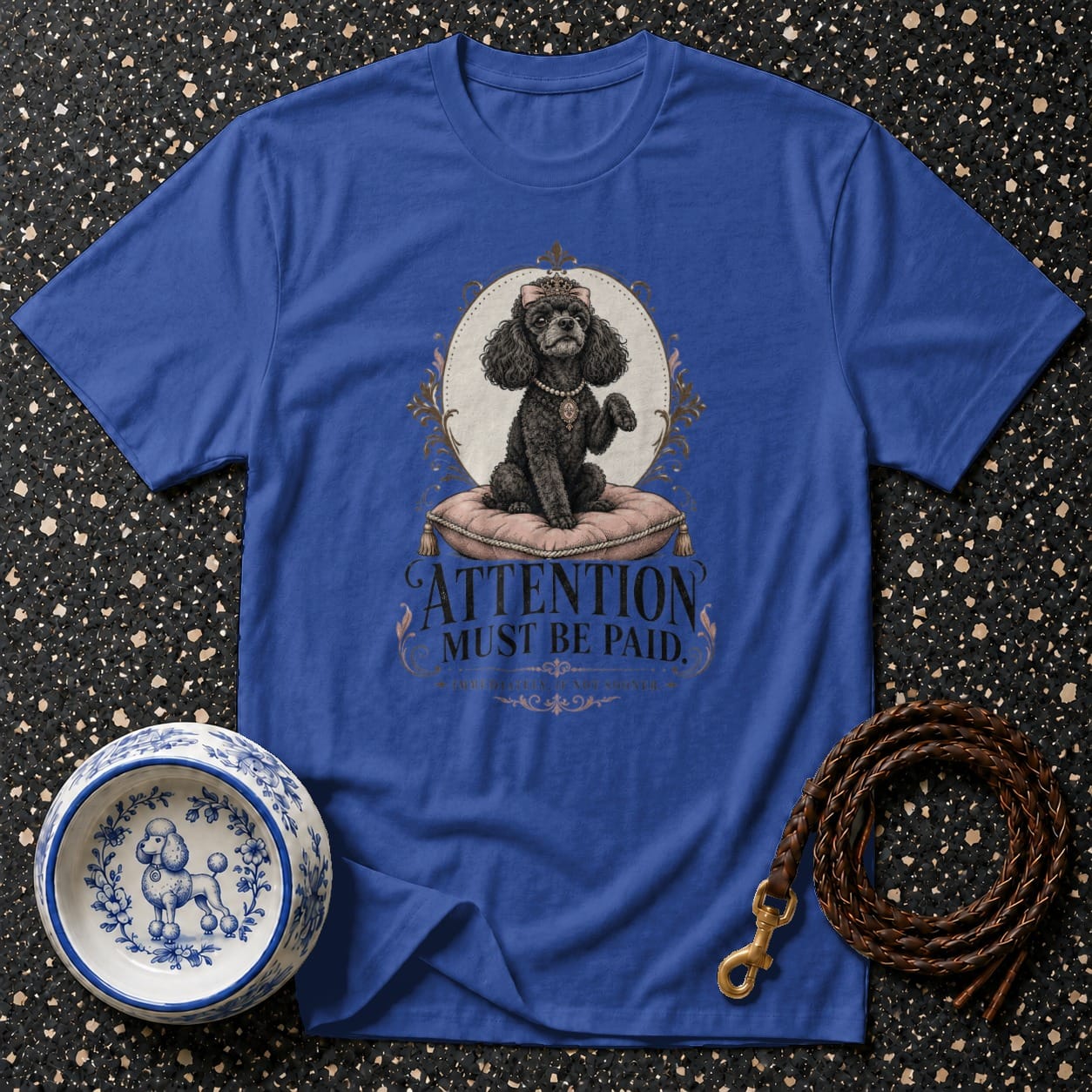Blue graphic t-shirt with black poodle in ornate frame and text reading "ATTENTION MUST BE PAID".
