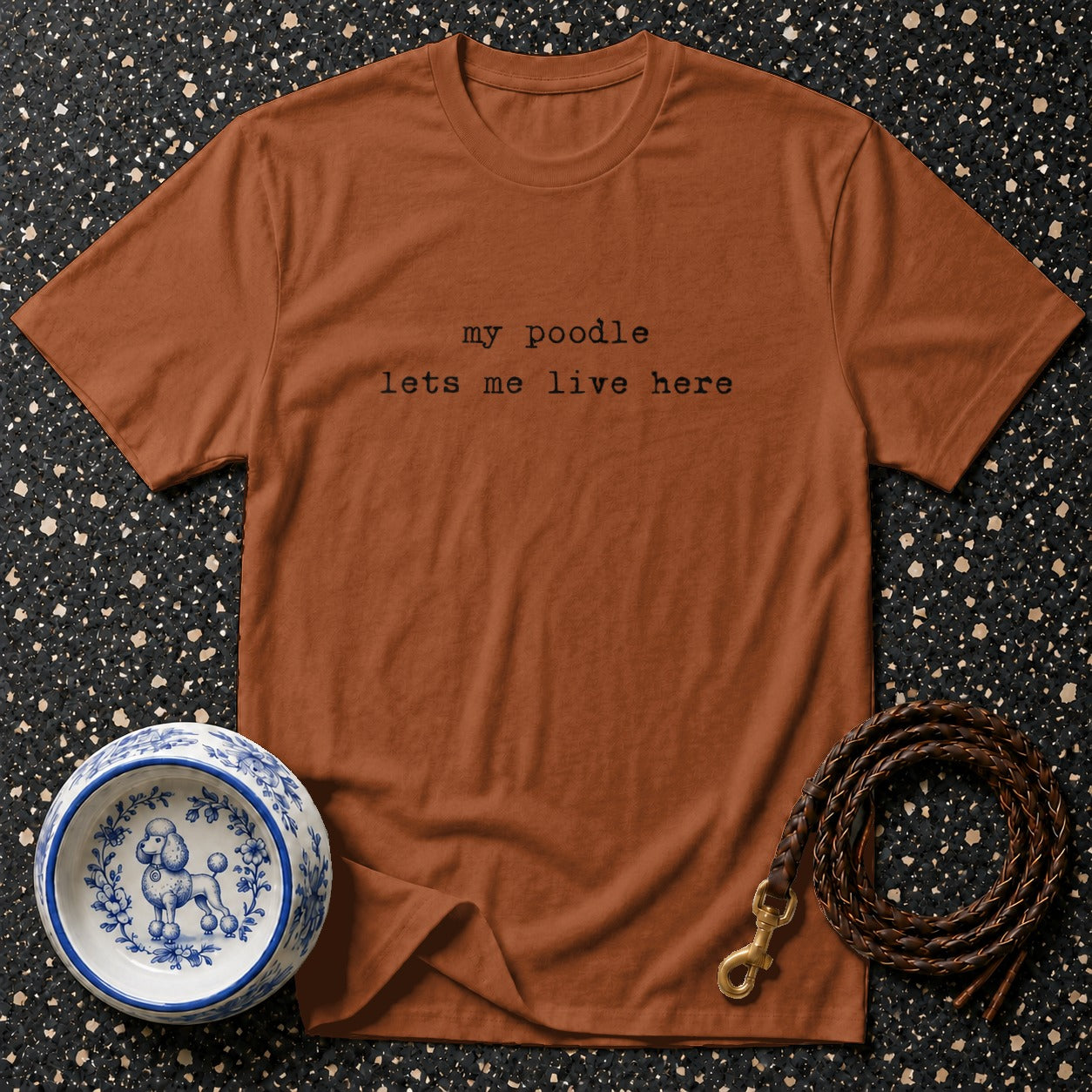 Brown t-shirt with black text "my poodle lets me live here."