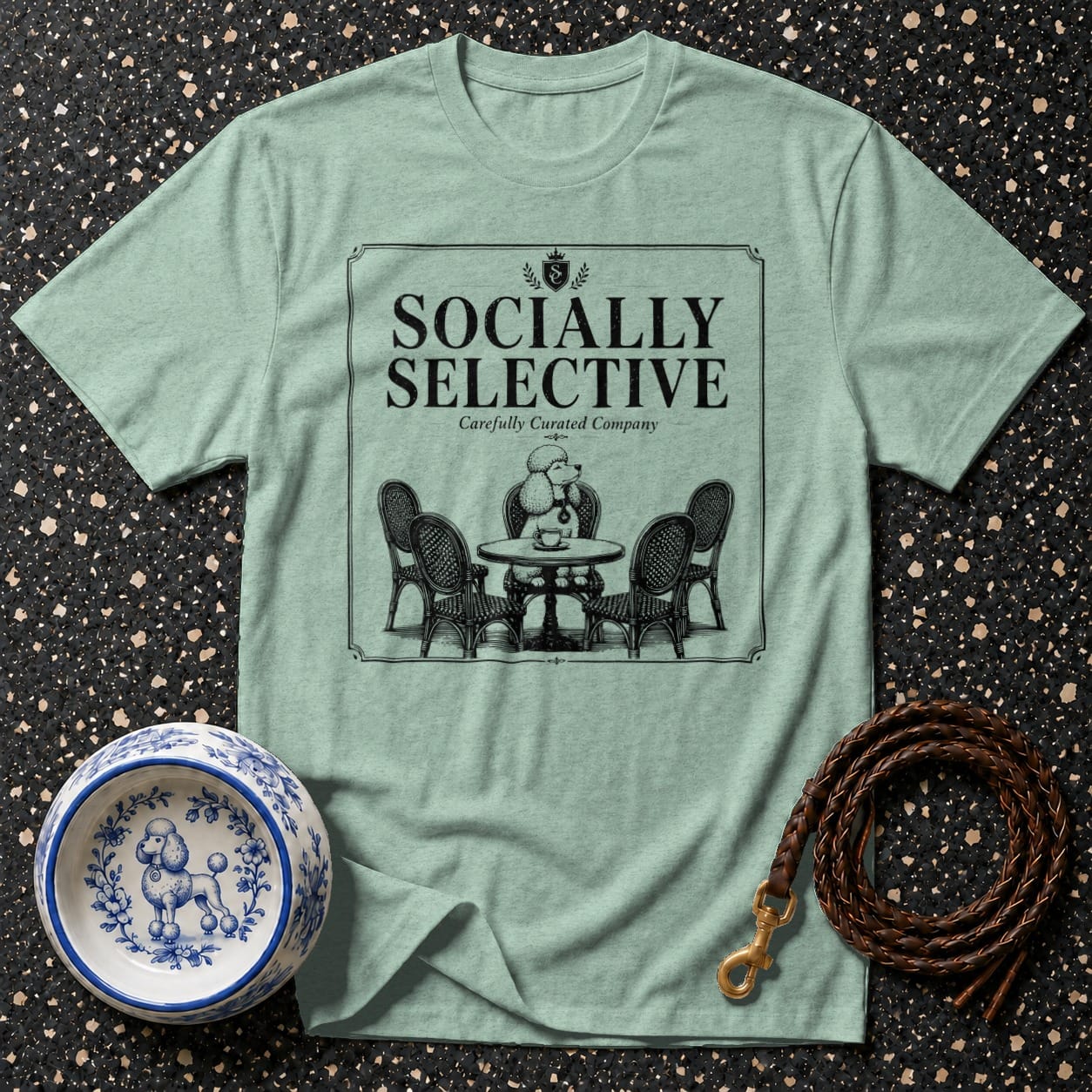 Light green t-shirt with "Socially Selective" text and poodle at ornate table graphic.