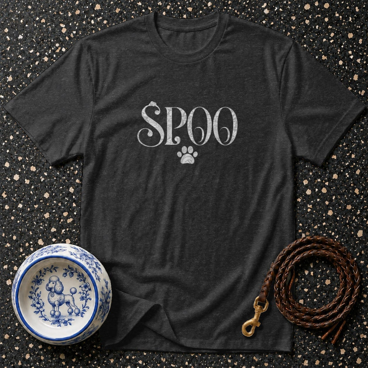 Dark gray t-shirt with "Spoo" text and paw print, next to a poodle bowl and leash.
