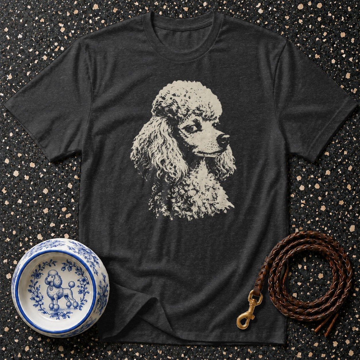 Charcoal t-shirt with a cream poodle graphic, blue and white dog bowl, and braided leather leash.