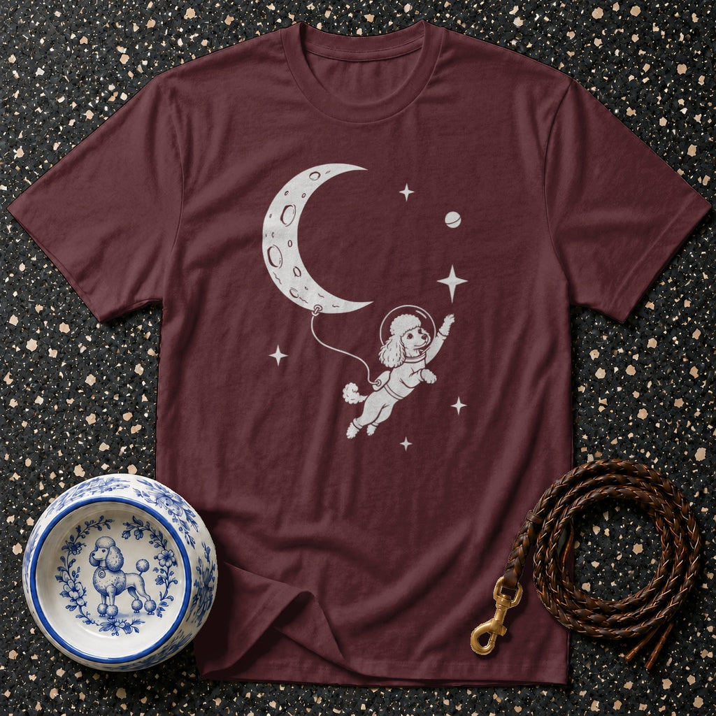 Maroon t-shirt with white graphic of a poodle in a spacesuit floating by the moon.