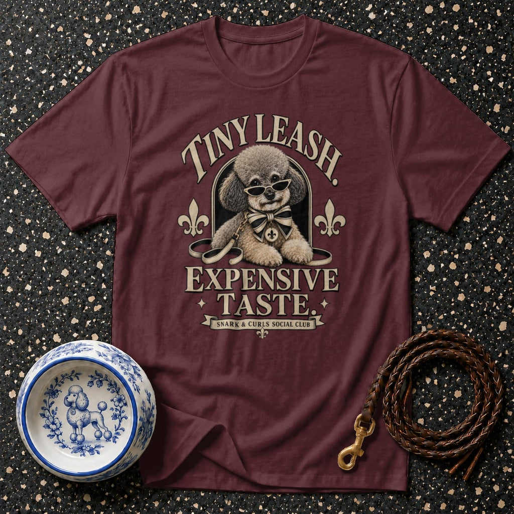 Maroon t-shirt with a poodle wearing sunglasses and a bow tie, with text "Expensive Taste".