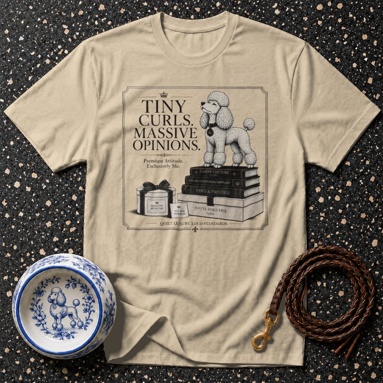 Beige t-shirt with poodle on books, "Tiny Curls. Massive Opinions." text, and dog accessories.