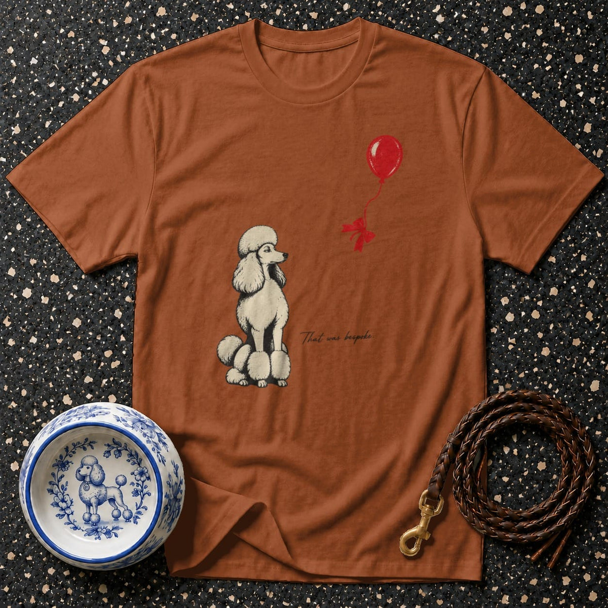 Brown t-shirt with poodle and balloon graphic, "That was bespoke" text.