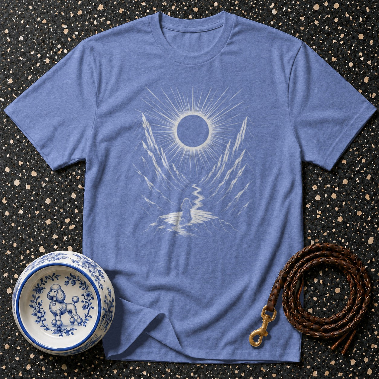 Blue t-shirt with graphic of a person facing a sun over mountains and river.