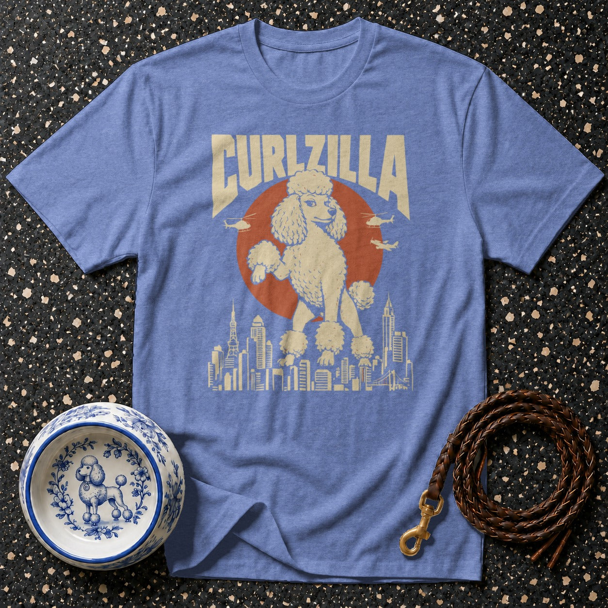 Light blue t-shirt with "CURLZILLA" text and a poodle above a city skyline.