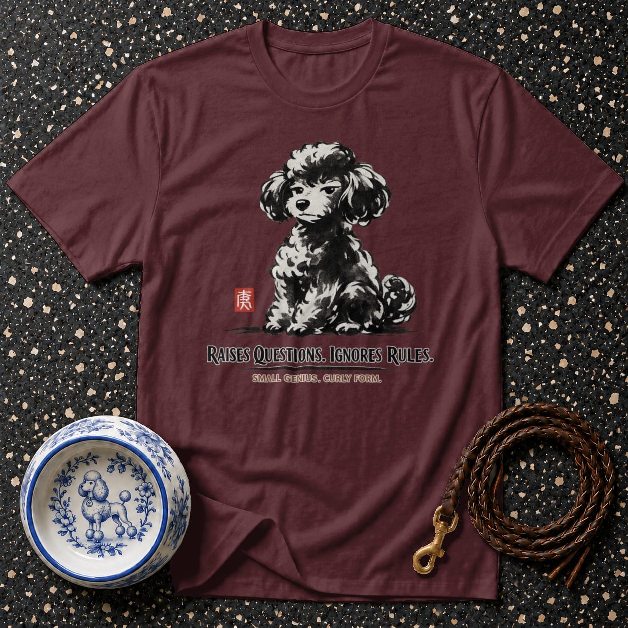 Maroon t-shirt with black poodle art and text: "RAISES QUESTIONS. IGNORES RULES."