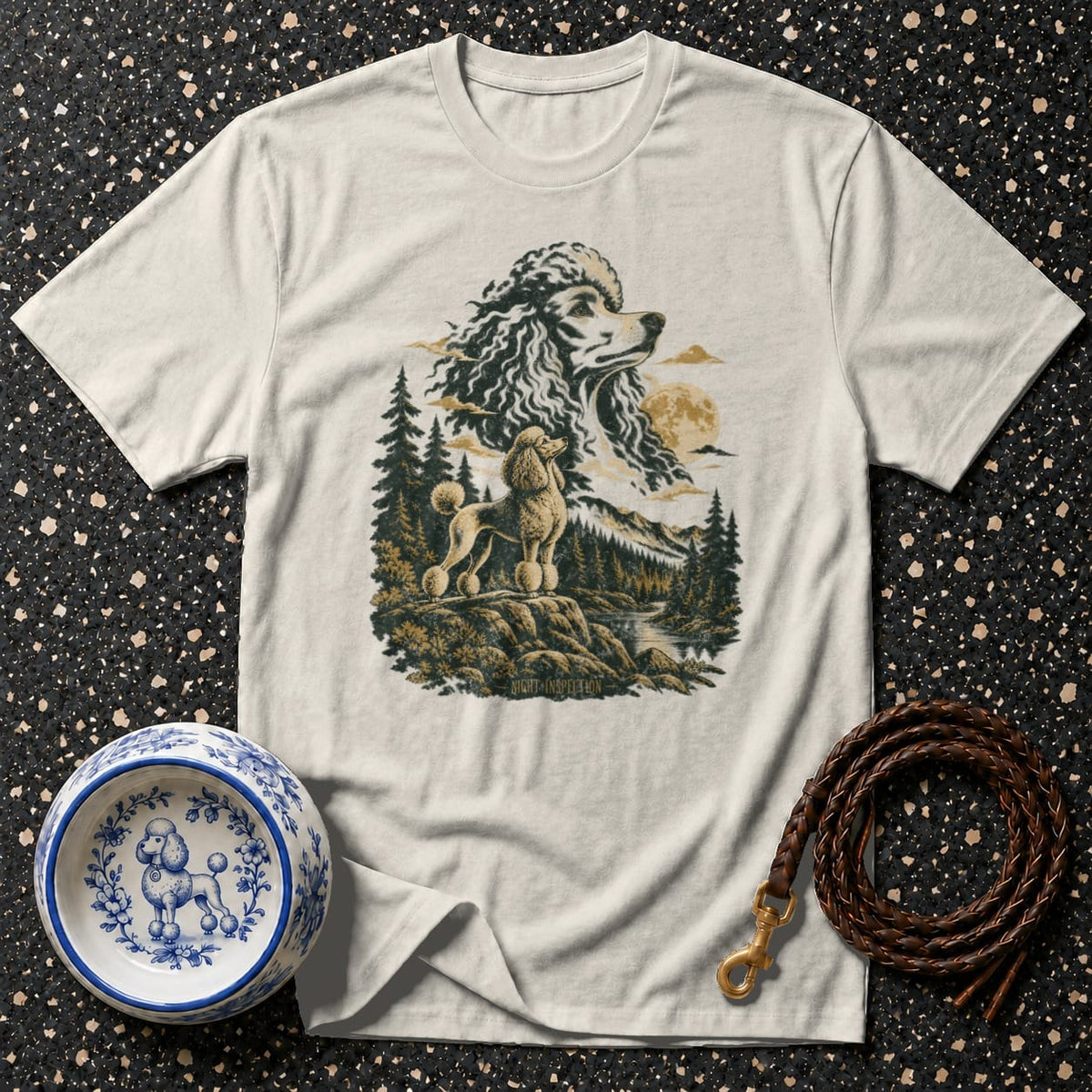 Light t-shirt with a vintage-style poodle illustration featuring a landscape and text "NIGHT INSPECTION."